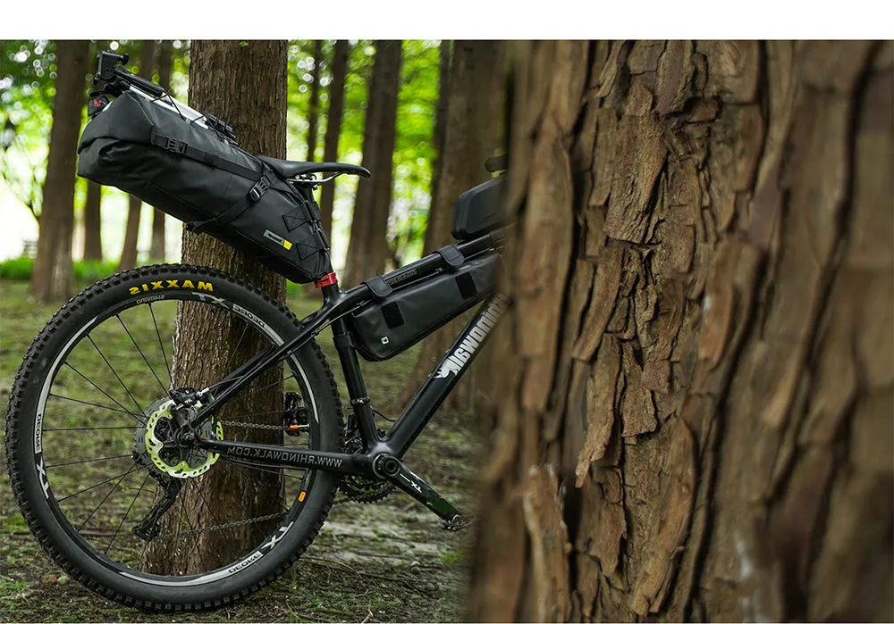 Bicicleta con alforja de sillín grande en un bosque, lista para bikepacking
