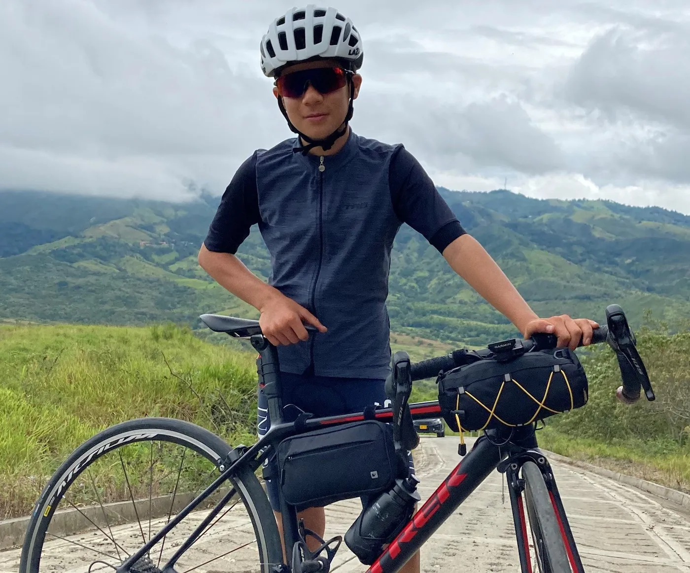 Ciclista con su bicicleta de ruta equipada con un bolso de manubrio Tingua Bag